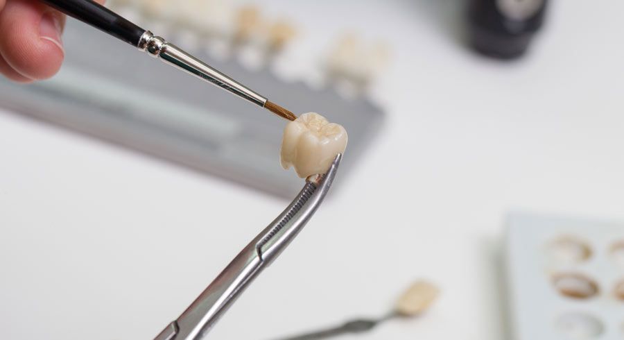 Technician applying shading to dental crown